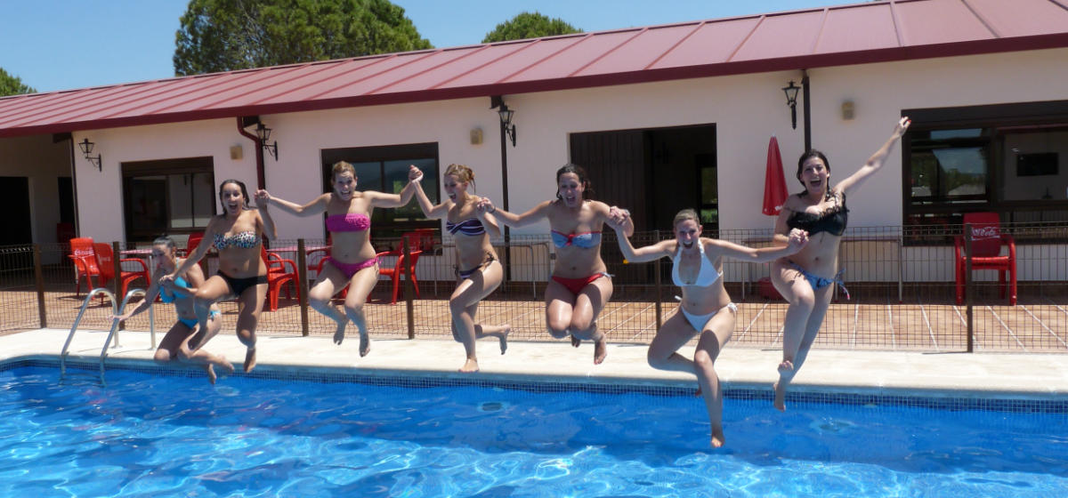 Chicas saltando a la piscina en una despedida de solteras